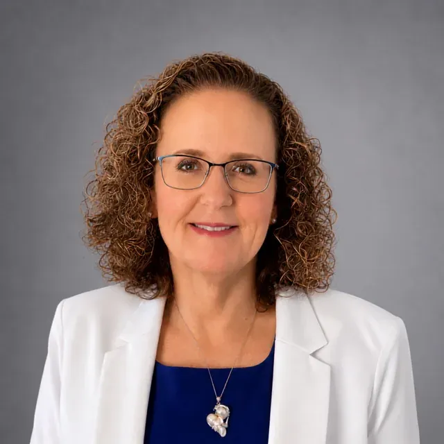Alissa Wakefield, smiling, in a white blazer